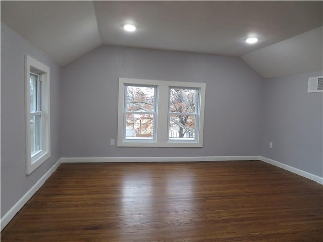 additional living space featuring dark wood-type flooring and vaulted ceiling