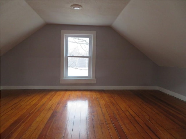 additional living space with lofted ceiling and hardwood / wood-style floors