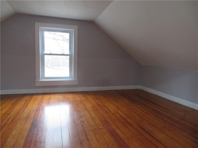 bonus room with wood-type flooring and vaulted ceiling