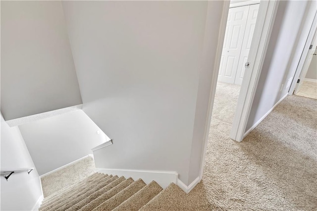 staircase featuring carpet and baseboards