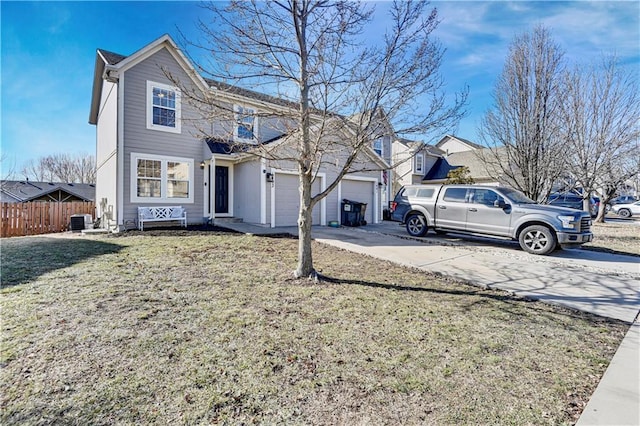 traditional-style home with driveway, an attached garage, fence, cooling unit, and a front yard