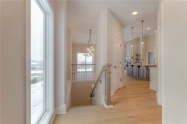 corridor featuring a chandelier and light hardwood / wood-style flooring