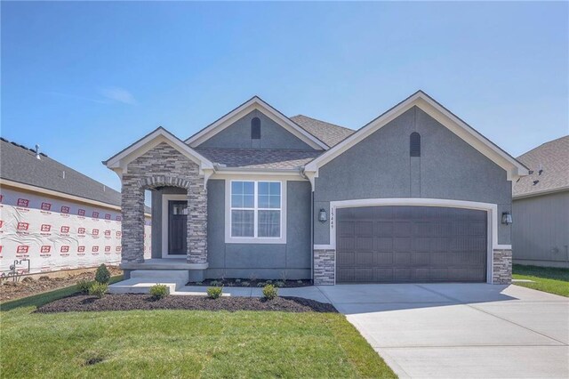 17351 S Kaw St, Olathe, KS 66062 - view of front of property featuring stone siding, a garage, driveway, stucco siding, and a front yard