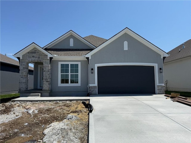 17351 S Kaw St, Olathe, KS 66062 - view of front facade with stone siding, a garage, driveway, and stucco siding