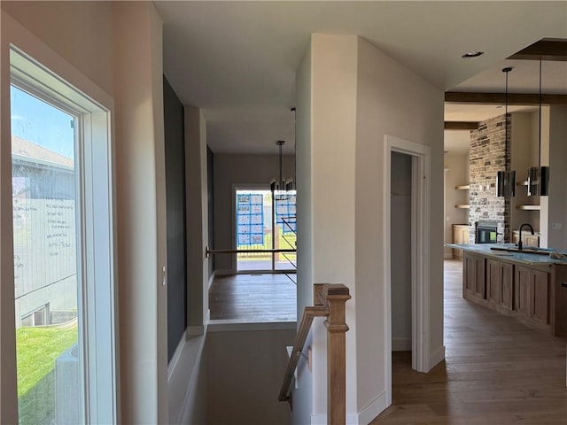 17351 S Kaw St, Olathe, KS 66062 - corridor with a sink, healthy amount of natural light, wood finished floors, and a chandelier