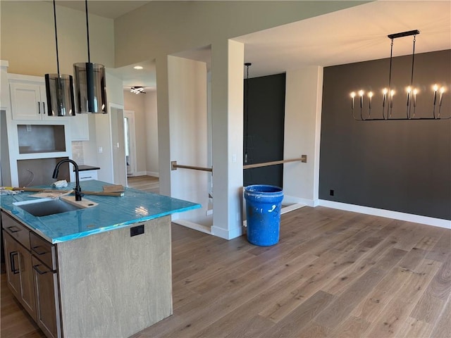 17351 S Kaw St, Olathe, KS 66062 - kitchen with a sink, light wood-type flooring, a chandelier, and baseboards