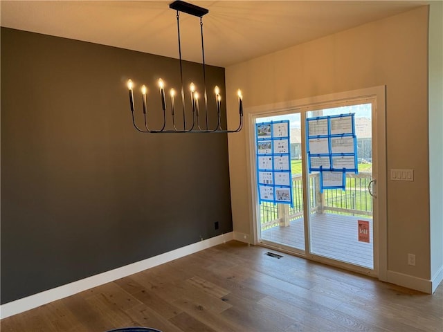 17351 S Kaw St, Olathe, KS 66062 - unfurnished dining area with wood finished floors, a chandelier, and baseboards