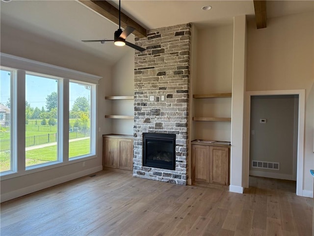17351 S Kaw St, Olathe, KS 66062 - unfurnished living room with a ceiling fan, light wood-style floors, a stone fireplace, and baseboards