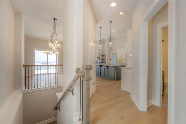 17351 S Kaw St, Olathe, KS 66062 - hall with an upstairs landing, light wood-style floors, a chandelier, recessed lighting, and baseboards