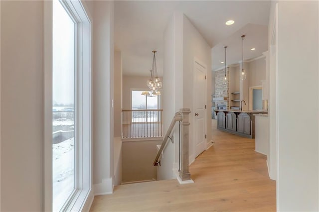 17351 S Kaw St, Olathe, KS 66062 - hall with an upstairs landing, light wood finished floors, a chandelier, recessed lighting, and baseboards