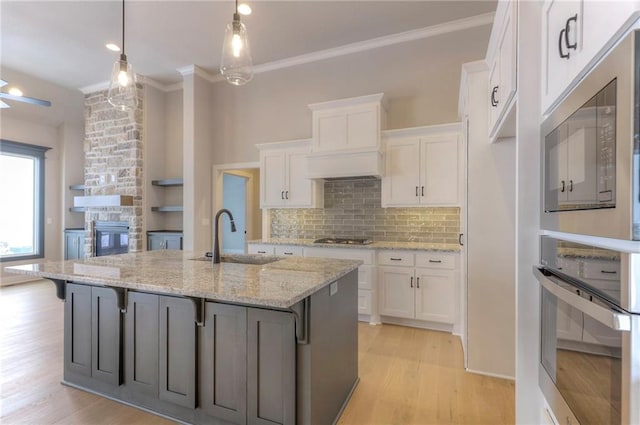 17351 S Kaw St, Olathe, KS 66062 - kitchen with appliances with stainless steel finishes, a sink, light wood-type flooring, white cabinetry, and ornamental molding