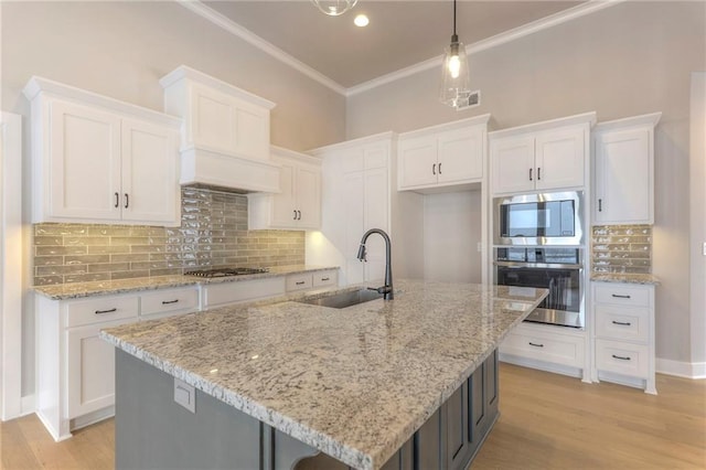 17351 S Kaw St, Olathe, KS 66062 - kitchen featuring stainless steel appliances, a sink, white cabinets, ornamental molding, and light wood finished floors