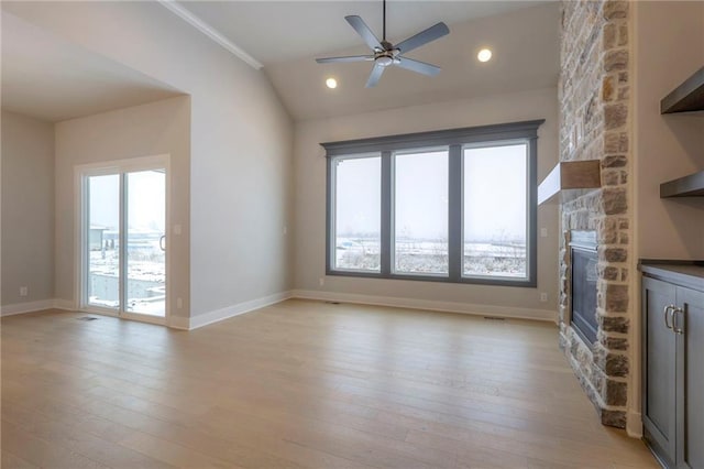17351 S Kaw St, Olathe, KS 66062 - unfurnished living room with a stone fireplace, lofted ceiling, ceiling fan, light wood-style floors, and baseboards