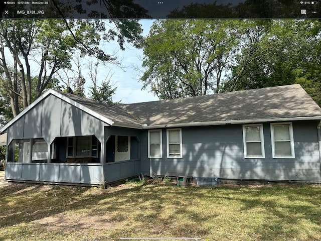 view of property exterior featuring a lawn and a sunroom