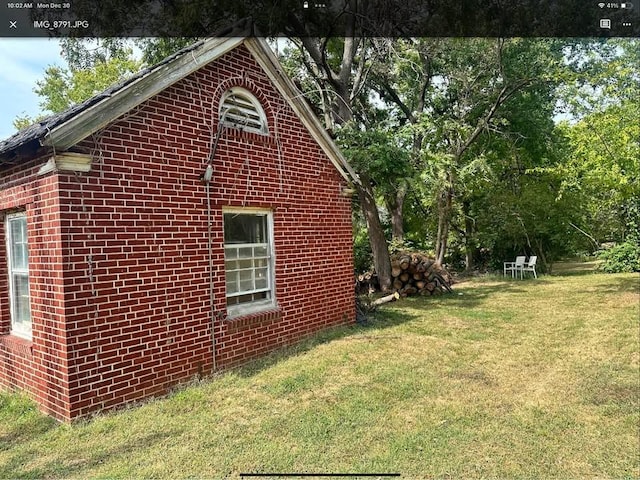 view of side of home featuring a yard and brick siding