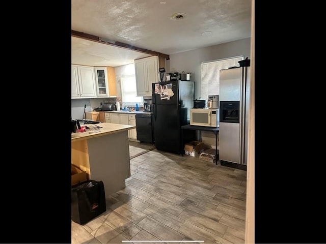 kitchen featuring white cabinets, black appliances, glass insert cabinets, and light wood-style floors