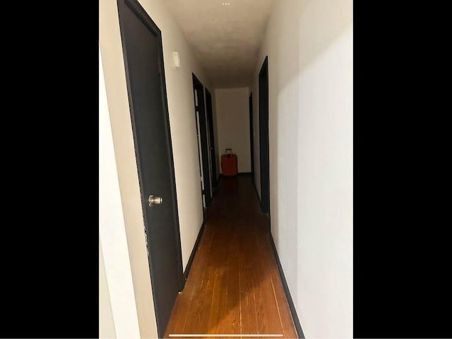 hallway with wood finished floors and baseboards