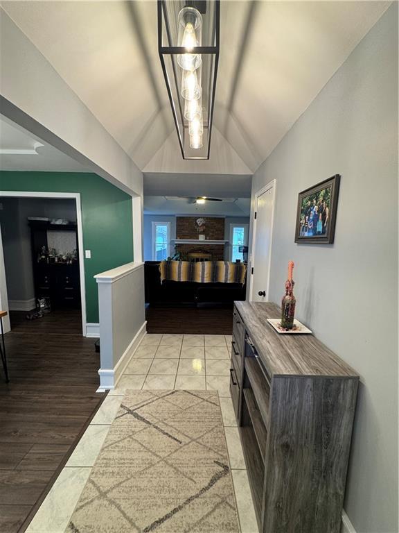 hall featuring lofted ceiling and light tile patterned floors