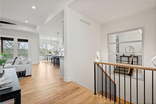 corridor with sink and light hardwood / wood-style flooring