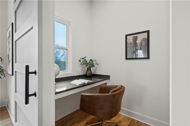 office space featuring built in desk and light hardwood / wood-style floors