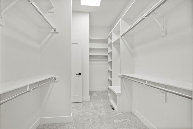 walk in closet featuring light carpet