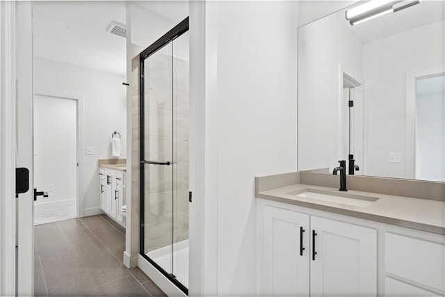 bathroom featuring vanity, tile patterned floors, and a shower with door