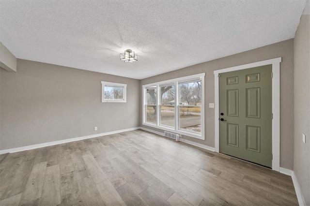 entrance foyer featuring light hardwood / wood-style floors and a textured ceiling