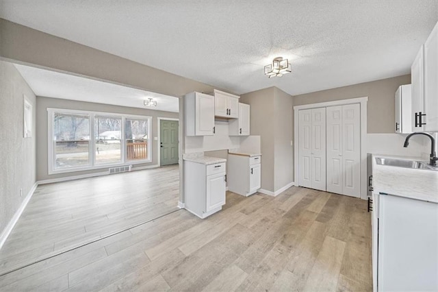 kitchen featuring sink, white cabinets, and light hardwood / wood-style floors