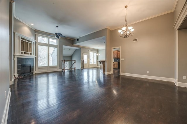 unfurnished living room featuring a tile fireplace, dark wood-type flooring, ceiling fan with notable chandelier, and crown molding