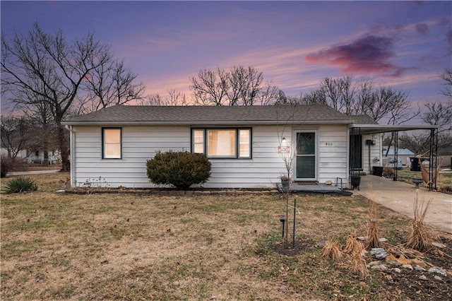 single story home featuring a carport and a lawn