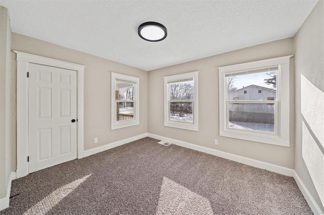 carpeted spare room with a textured ceiling