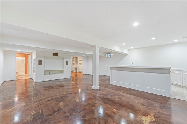 finished basement with wet bar, a sink, and recessed lighting