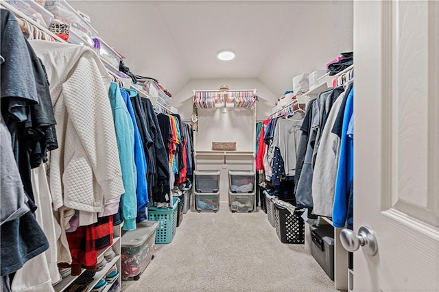 walk in closet with vaulted ceiling and carpet flooring