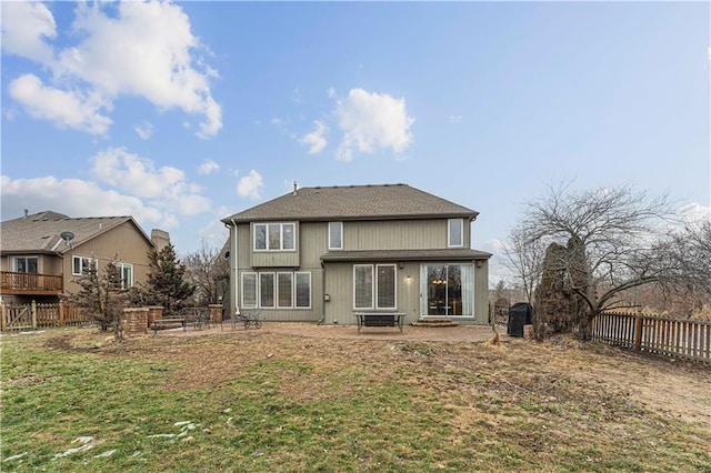 rear view of house with a patio, a yard, and fence