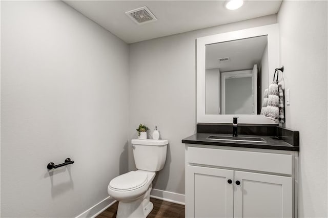 bathroom featuring hardwood / wood-style flooring, vanity, and toilet