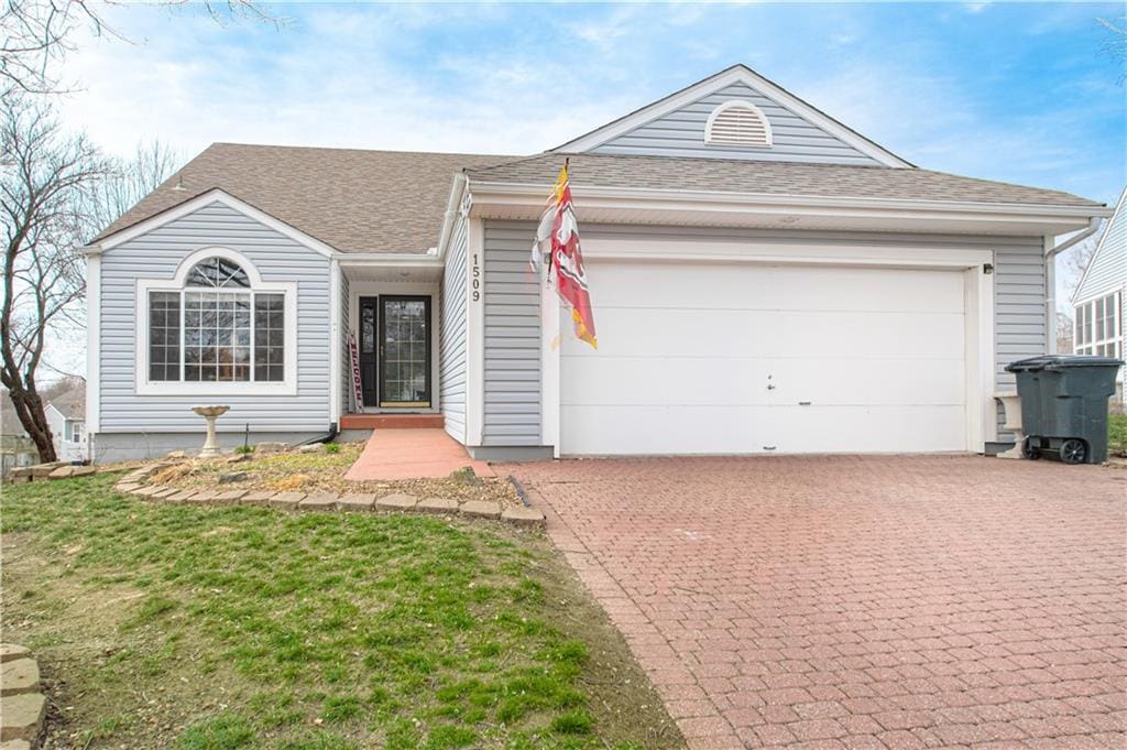 single story home with a garage and a front lawn