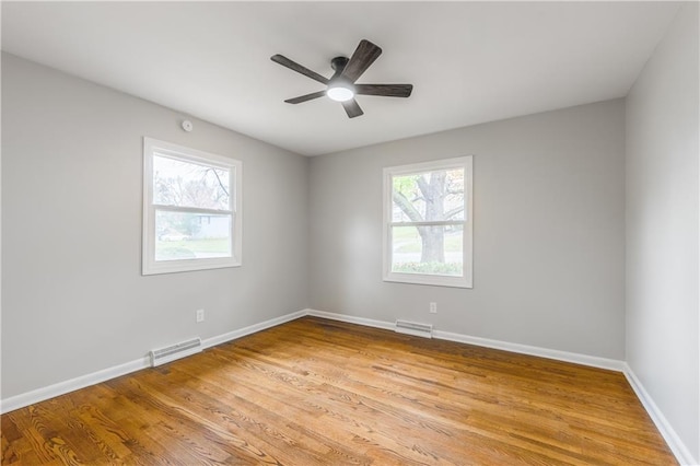 empty room featuring ceiling fan, light hardwood / wood-style floors, and a wealth of natural light