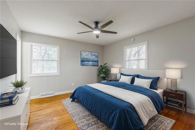 bedroom with multiple windows, hardwood / wood-style floors, and ceiling fan