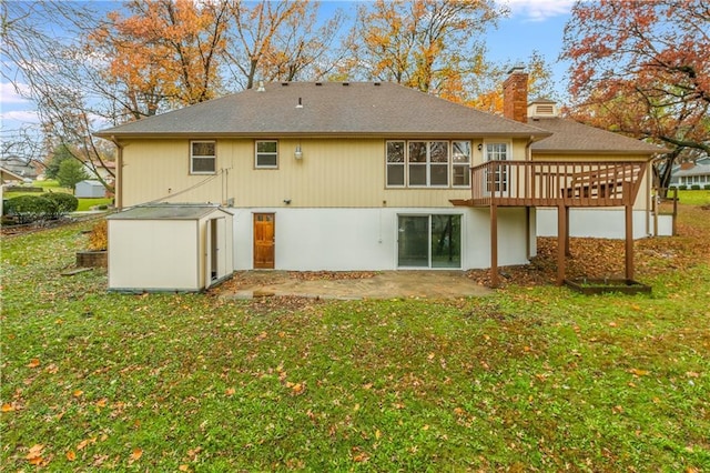 rear view of property featuring a yard, a deck, and a patio