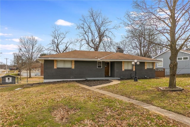 ranch-style home featuring a front lawn, a chimney, fence, and brick siding