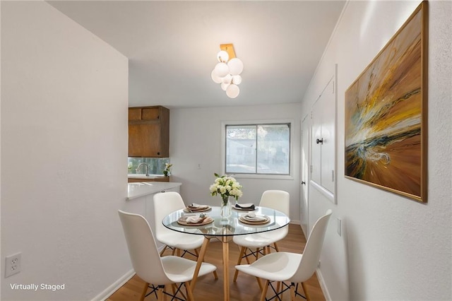 dining room with light wood-type flooring and baseboards