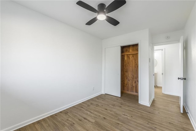 unfurnished bedroom featuring a ceiling fan, light wood-type flooring, a closet, and baseboards