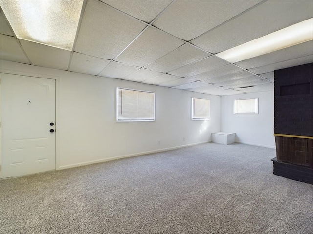 below grade area with carpet floors, a paneled ceiling, and baseboards