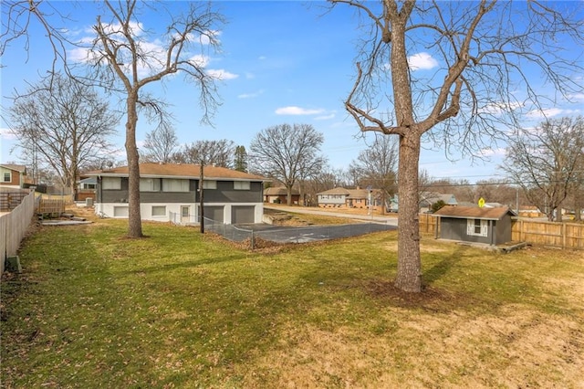 view of yard with a residential view, fence, and an outbuilding