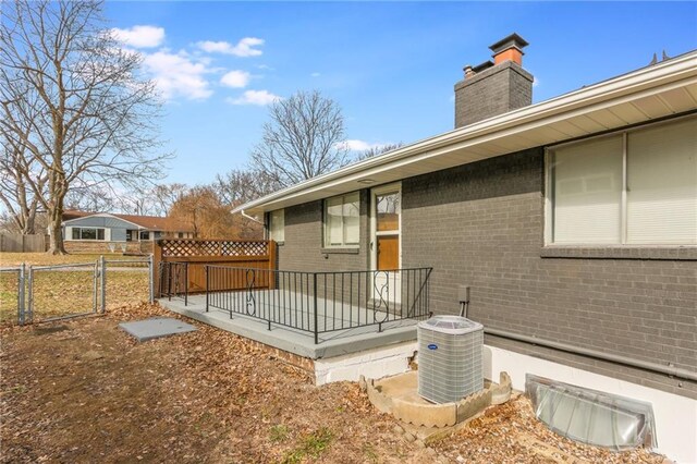 exterior space with a gate, fence, and cooling unit