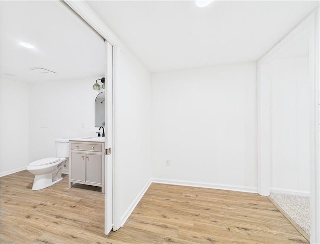 3201 S Norton Ave, Independence, MO 64052 - bathroom with baseboards, wood finished floors, toilet, and vanity