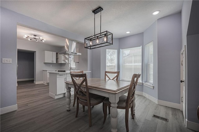 dining space featuring hardwood / wood-style flooring and a textured ceiling