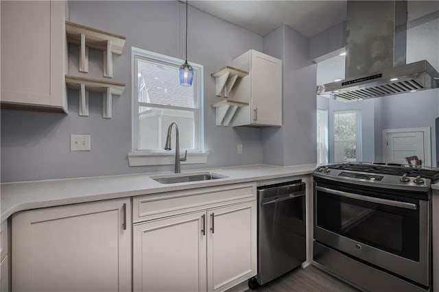 kitchen featuring white cabinetry, extractor fan, gas range, and decorative light fixtures