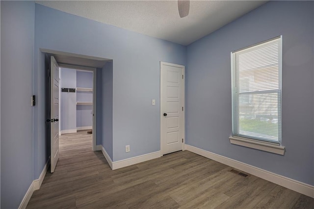 spare room featuring ceiling fan, dark hardwood / wood-style floors, and a textured ceiling