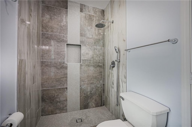 bathroom with tiled shower and toilet